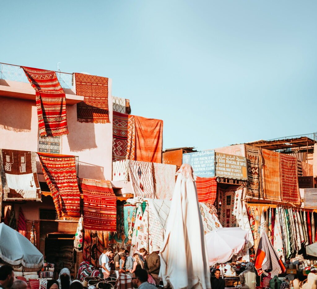 Colorful textiles hanging against the historic red walls of the medina of Marrakech